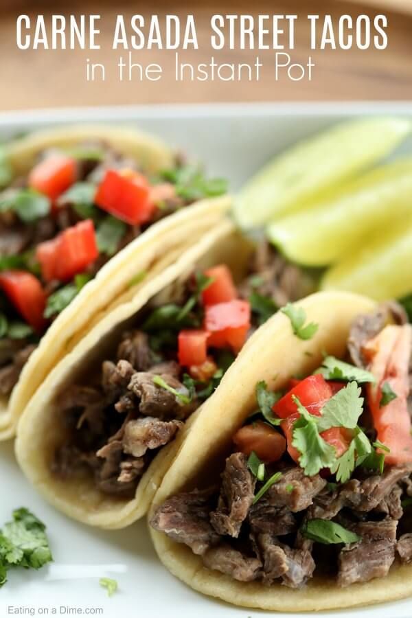 three tacos on a white plate with garnishes