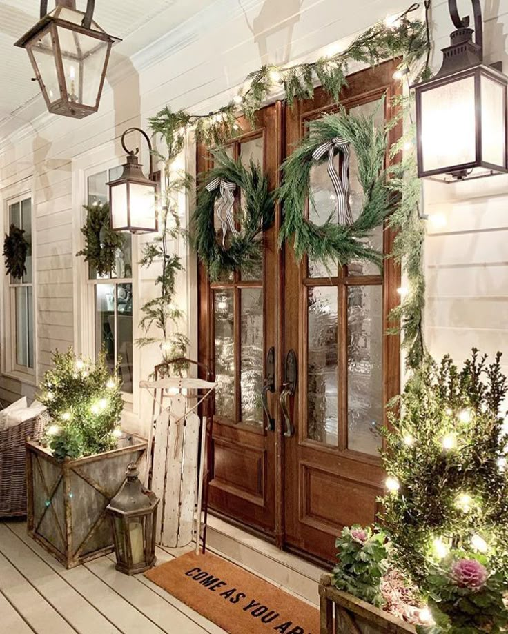 the front porch is decorated for christmas with wreaths and lights