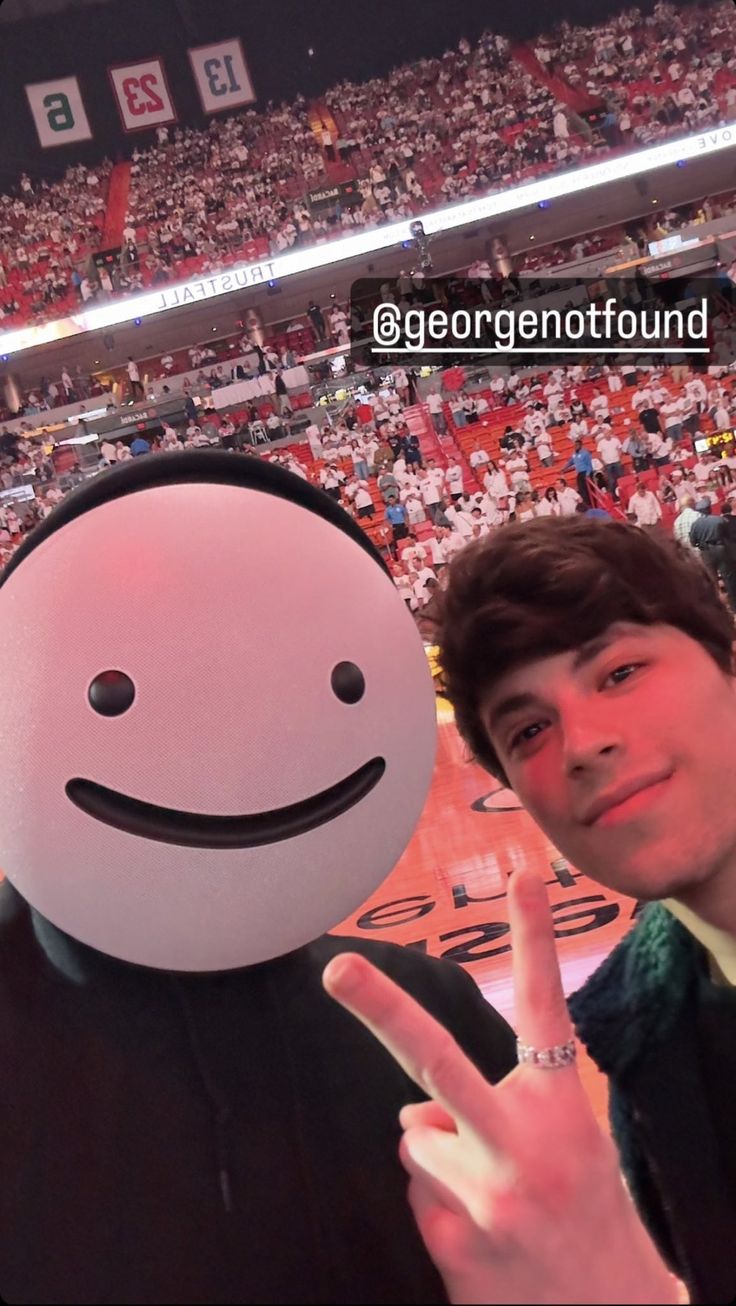 a man standing next to a smiley face at a basketball game