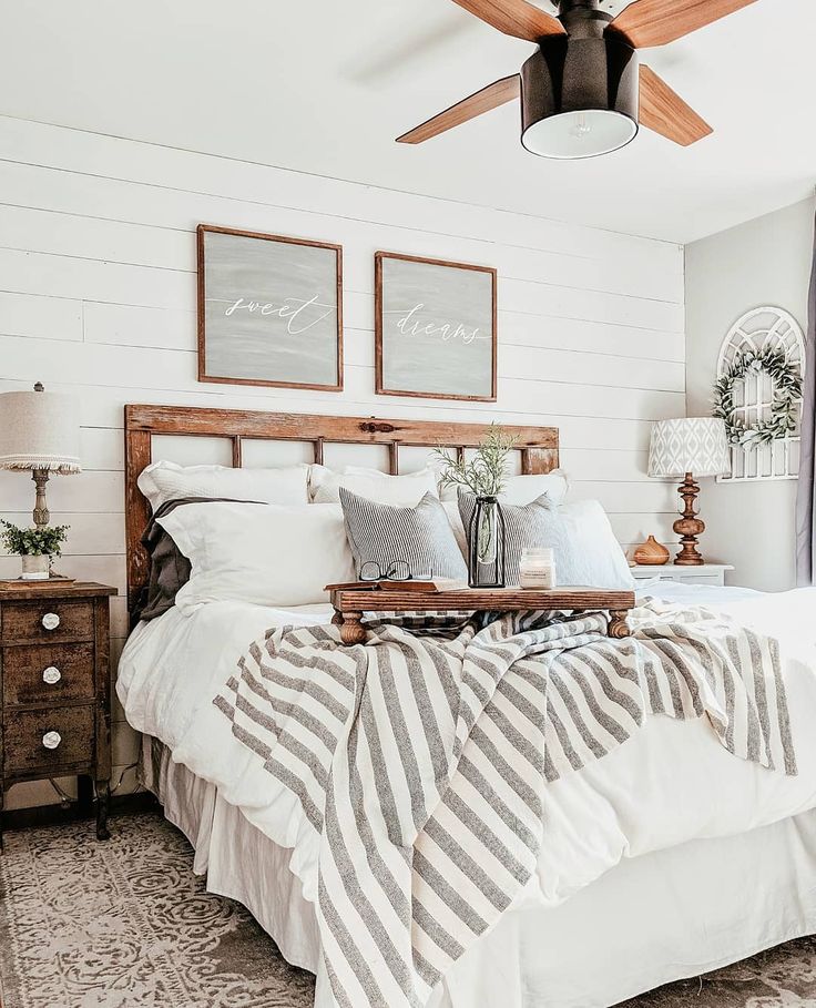 a bedroom with white bedding and wooden headboard