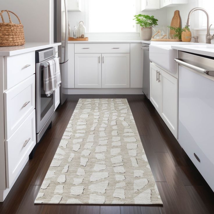 a kitchen with white cabinets and wood flooring next to an oven, dishwasher and microwave