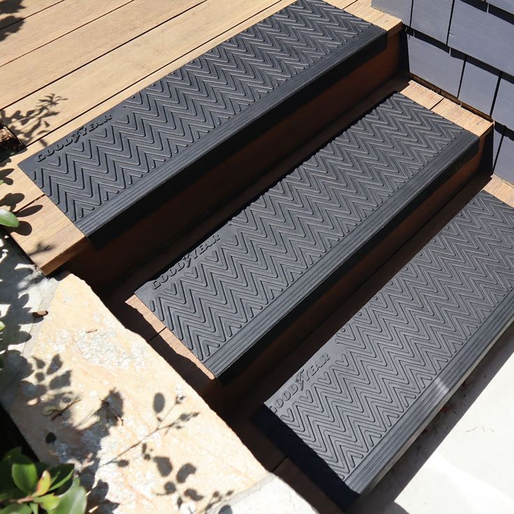 two black diamond treads sitting on top of a wooden deck next to plants and flowers