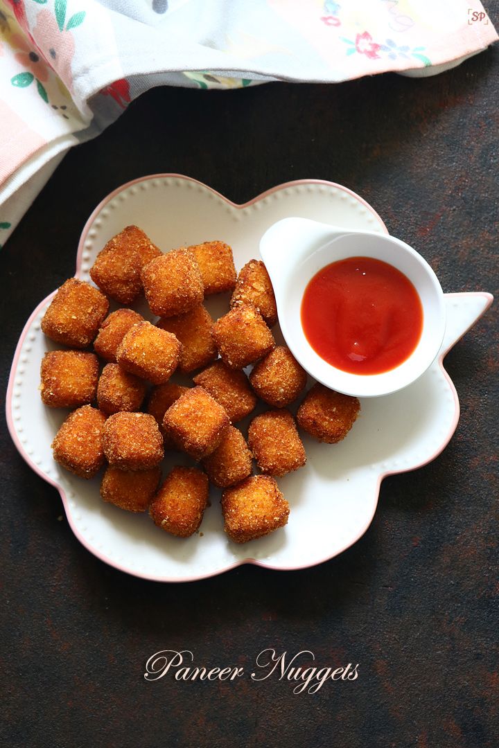 small pieces of fried food on a plate with ketchup in a bowl next to it