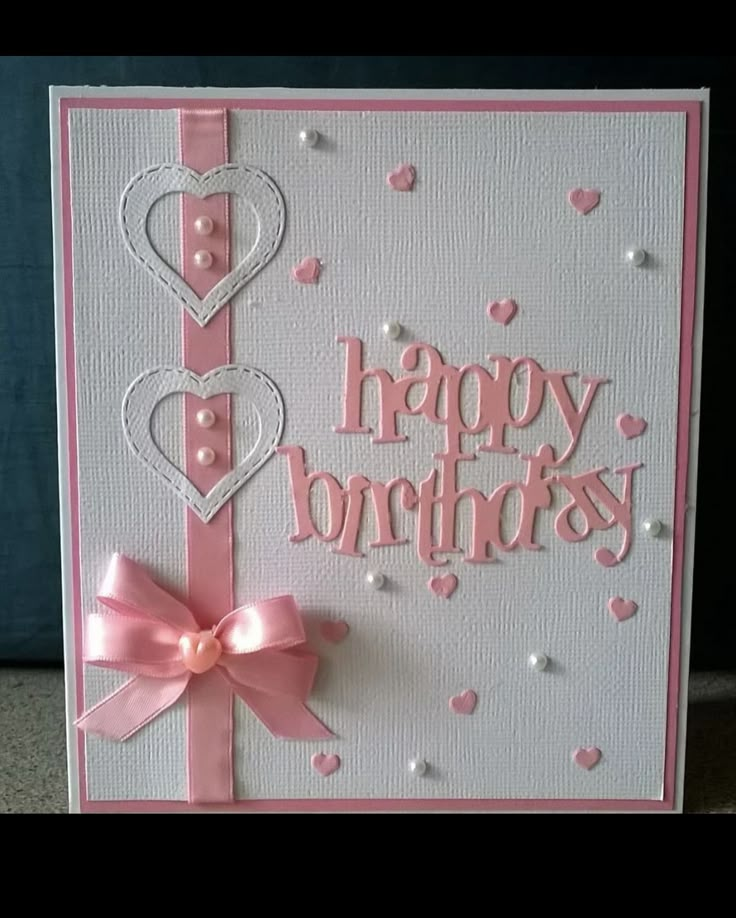 a handmade birthday card with pink ribbon and hearts