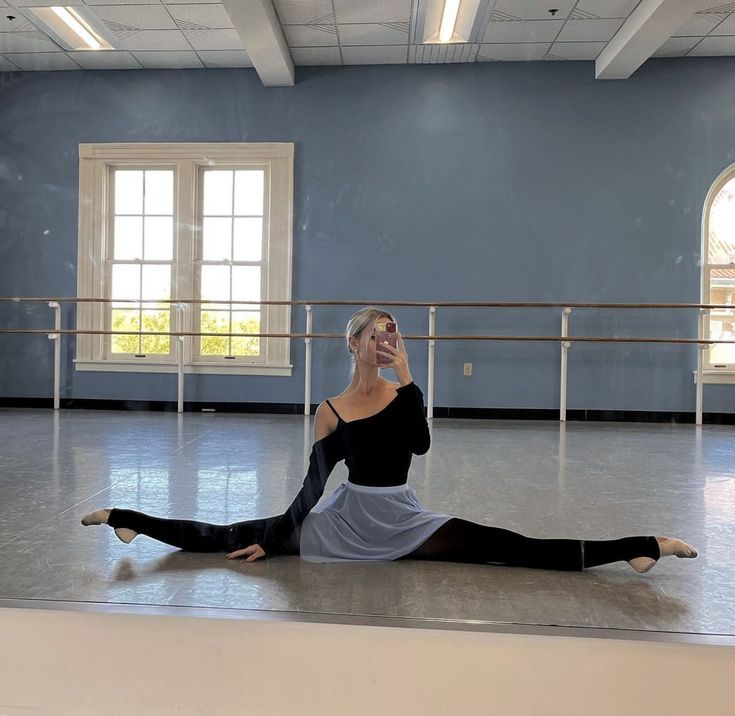 a woman sitting on the floor with her legs crossed and one leg up in the air