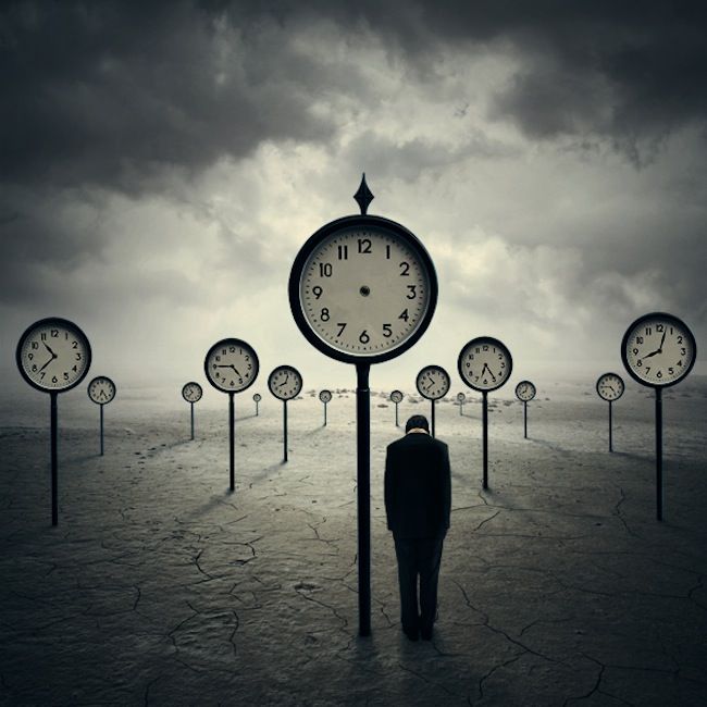 a man is standing in front of clocks