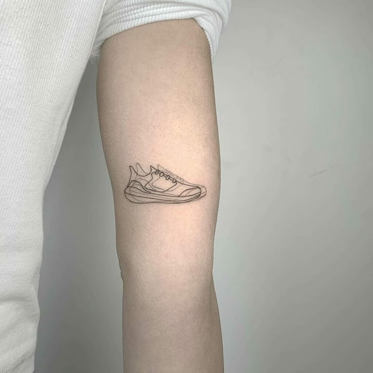 a person with a tattoo on their arm that has a sneaker shoe on it