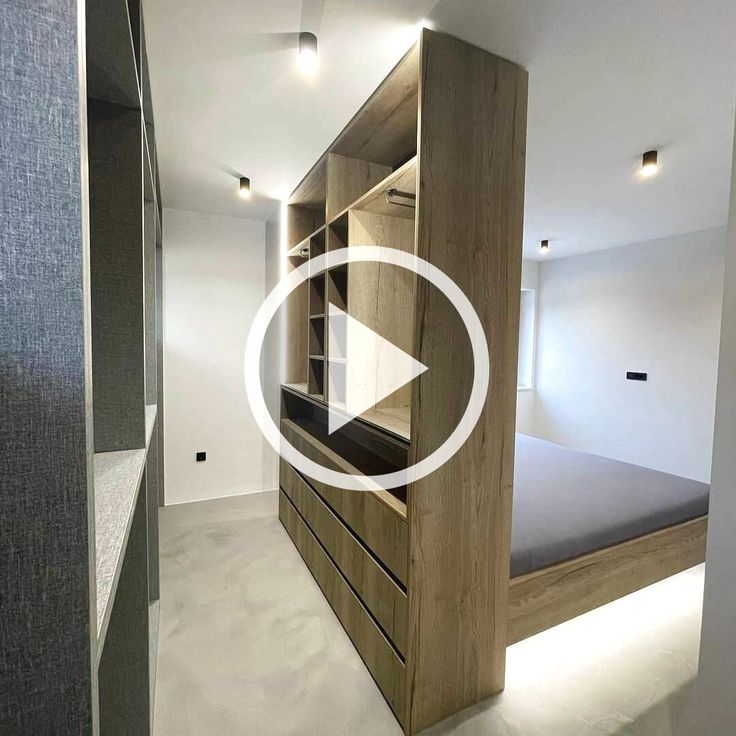 a bed sitting in the middle of a room next to a wooden shelf with drawers