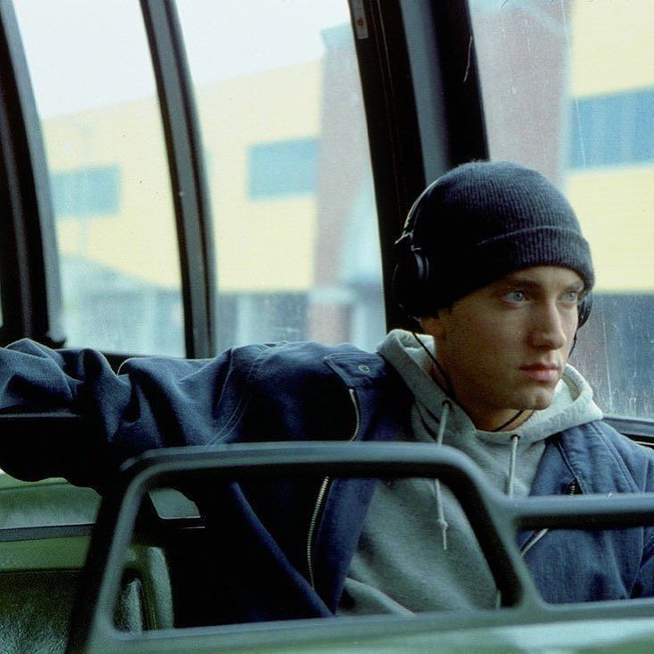 a young man wearing headphones sitting on a bus