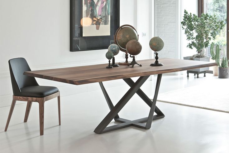 a wooden table with two chairs next to it and a mirror on the wall behind it