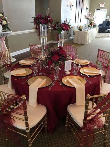 a table set with place settings and flowers in vases