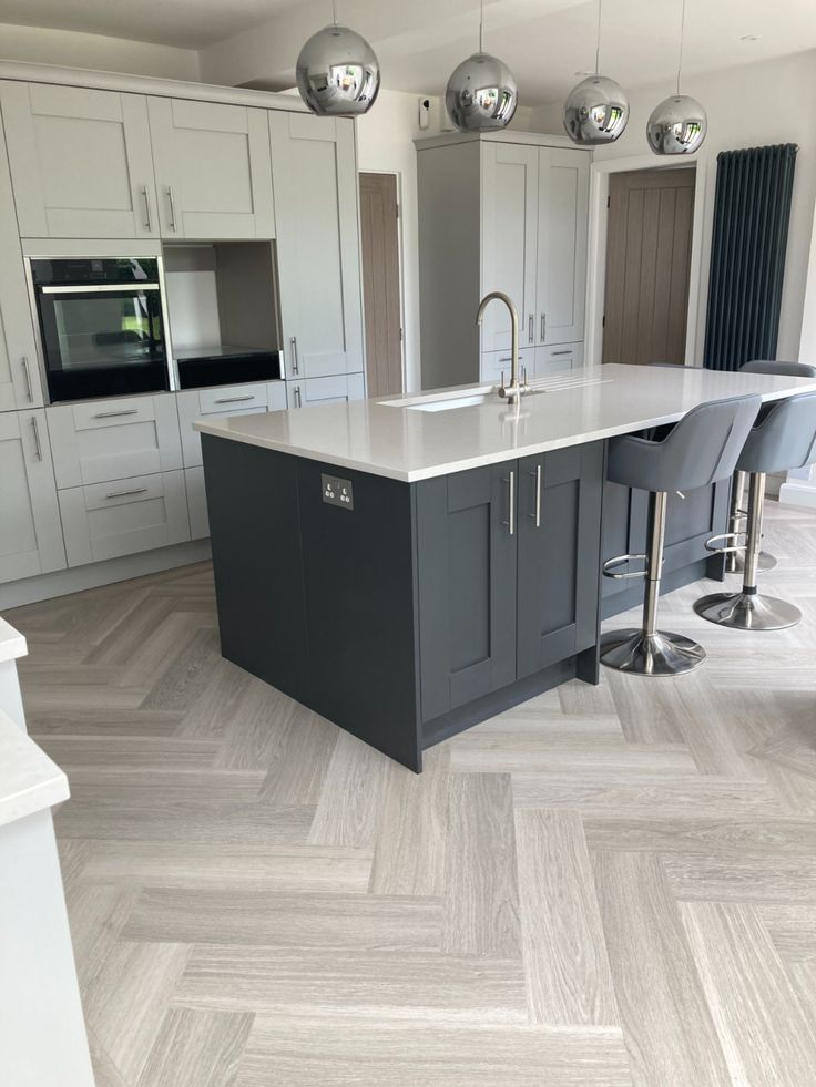 a large kitchen with an island and bar stools