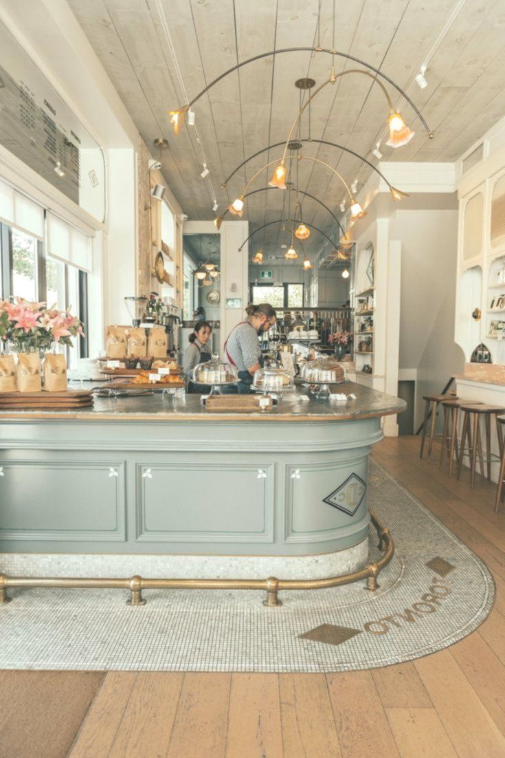 the interior of a coffee shop with people working behind the counter