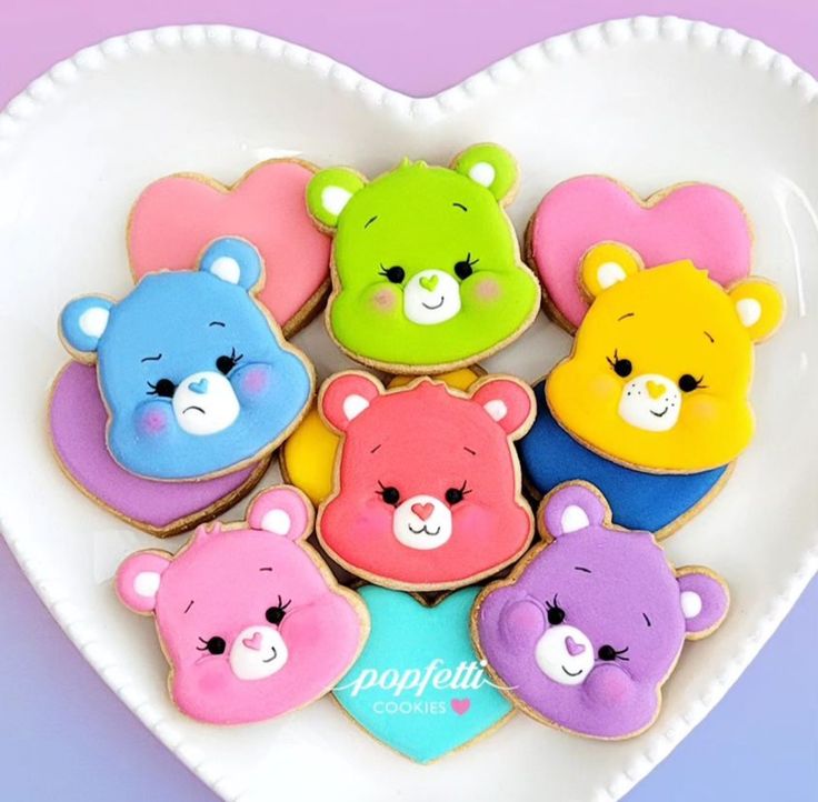 a heart shaped plate filled with cookies decorated like teddy bear's and other bears