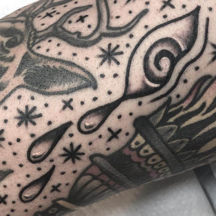 a close up of a person's arm with tattoos on it