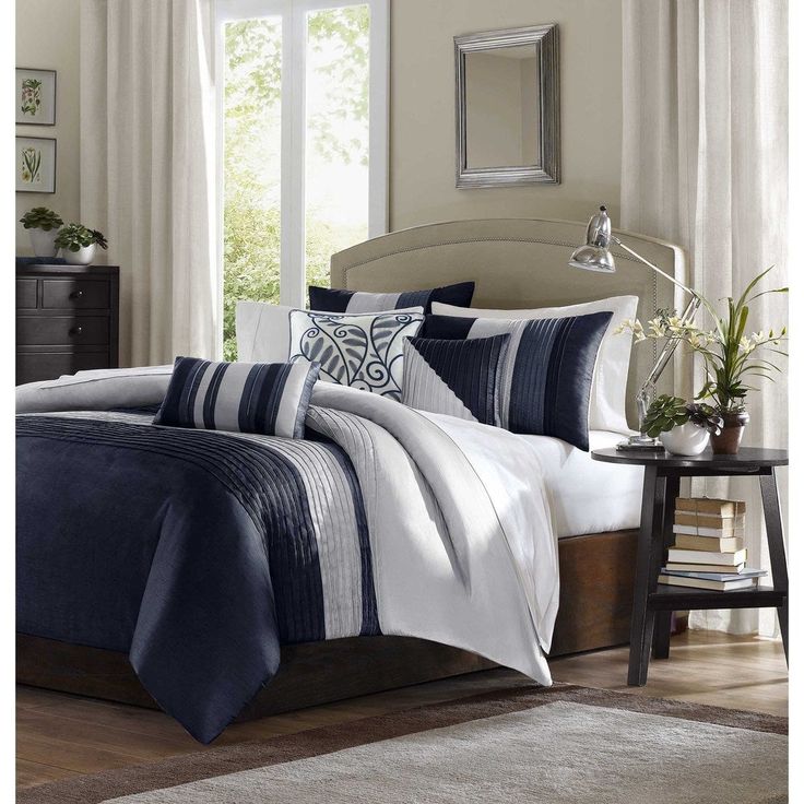 a bed with blue and white comforters in a bedroom