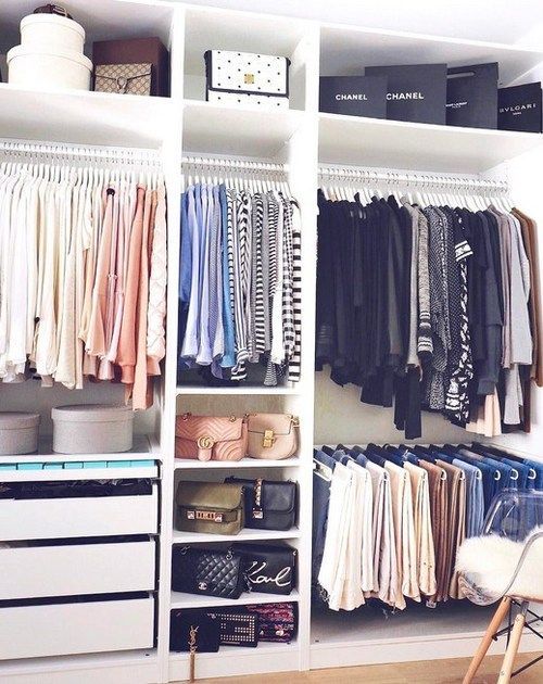 an organized closet with clothes, shoes and other items on shelves in front of it