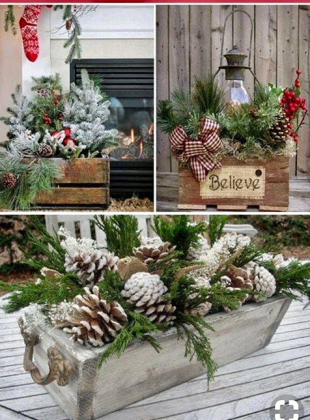 christmas decorations and pine cones are displayed in an old wooden box on a porch table