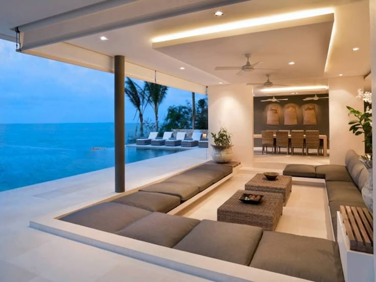 a living room filled with furniture next to the ocean