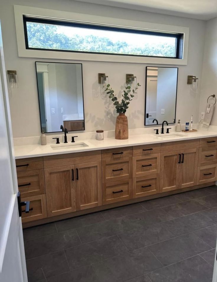 a large bathroom with double sinks and mirrors