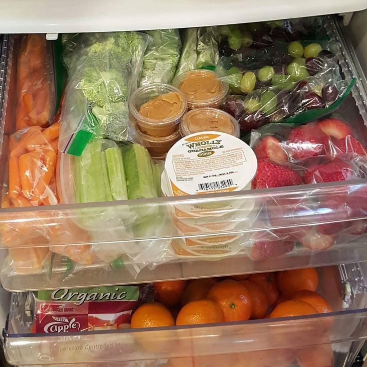 an open refrigerator filled with lots of different types of vegetables and eggs in plastic containers