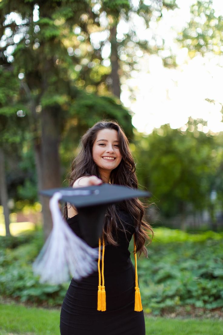 a woman in a black dress holding a frisbee and smiling at the camera