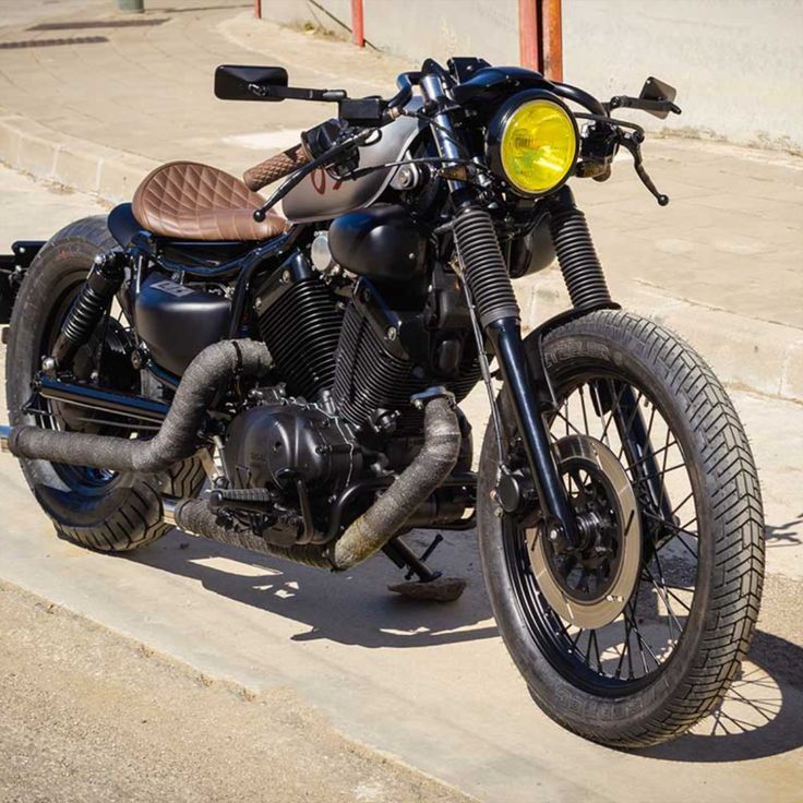 the motorcycle is parked on the side of the road near stairs and steps in front of a building