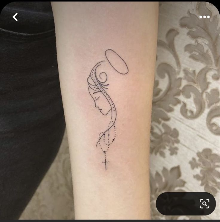 a woman's arm with a tattoo on it that has a cross in the middle