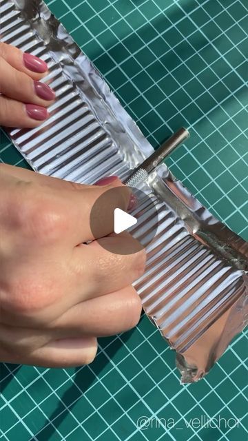 a woman is using scissors to cut metal strips