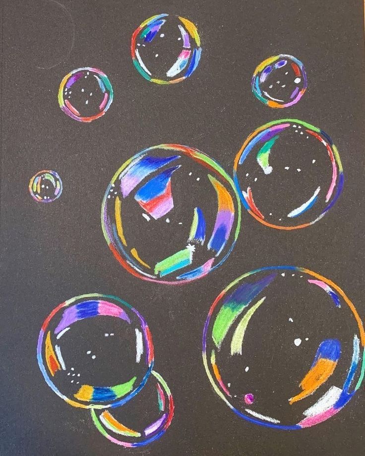 an image of soap bubbles drawn on black paper with colored crayon pencils