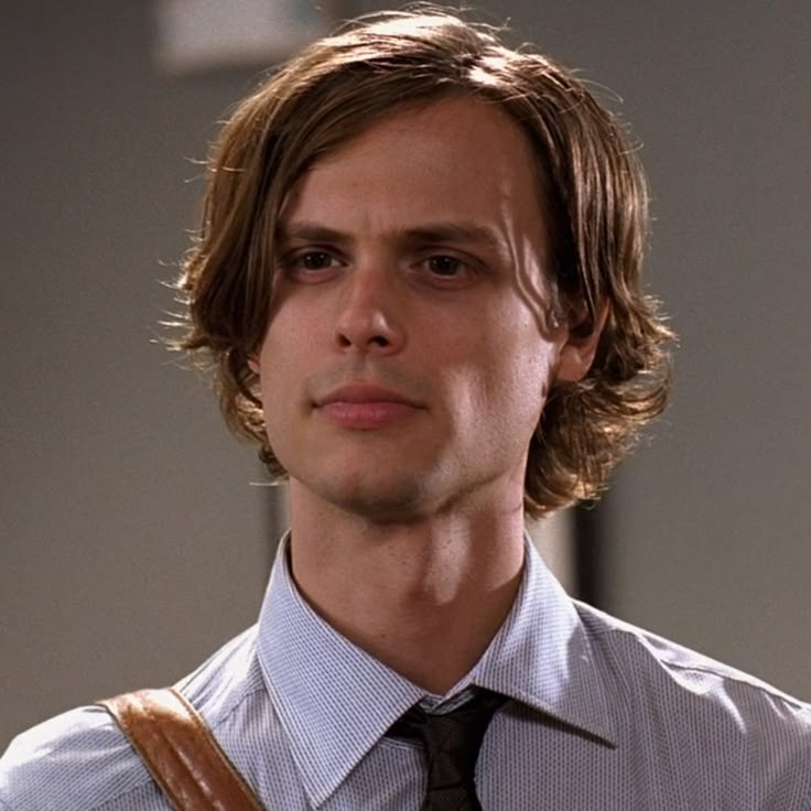 a man with long hair wearing a shirt and tie