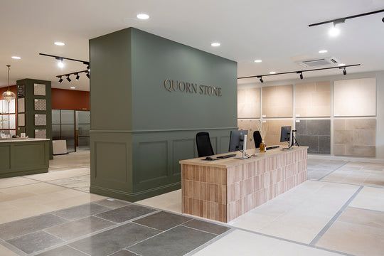 the interior of an office with tile flooring and green walls, along with two desks