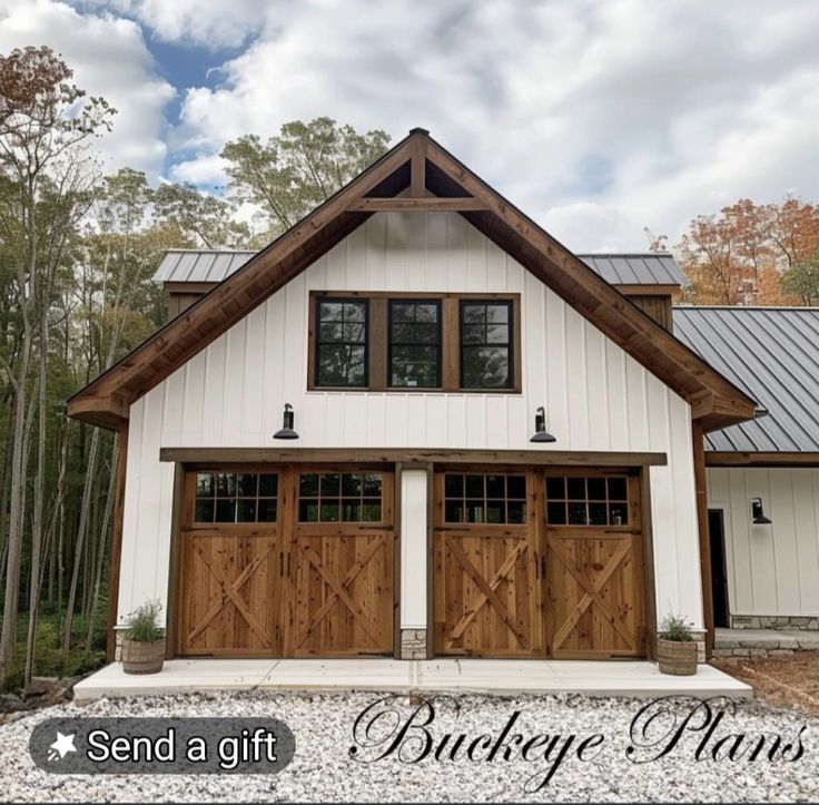 a white house with two brown garage doors