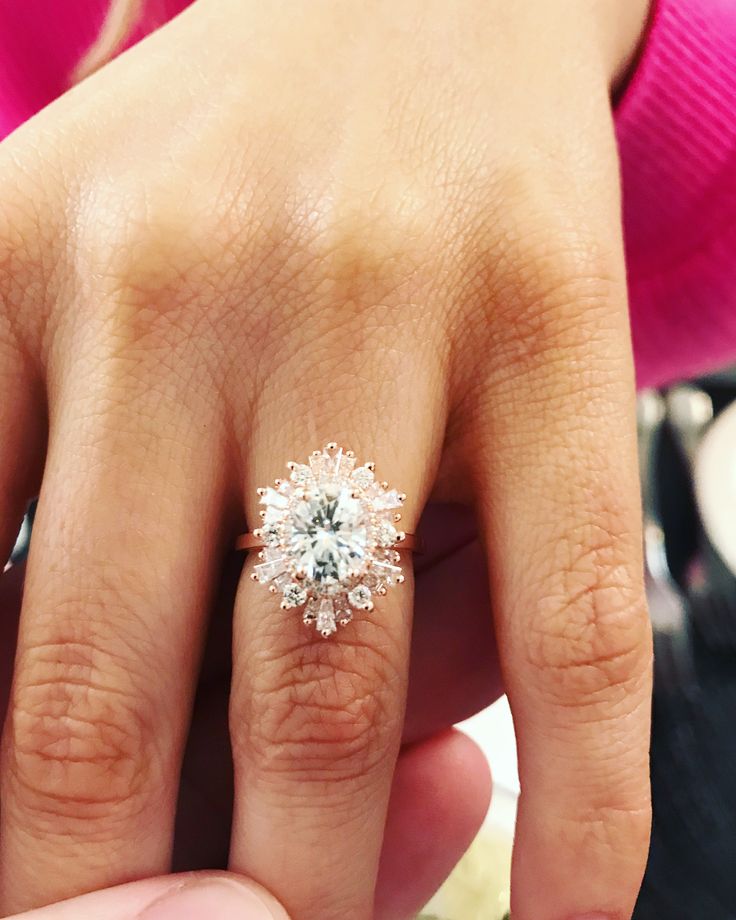 a close up of a person's hand with a diamond ring on their finger