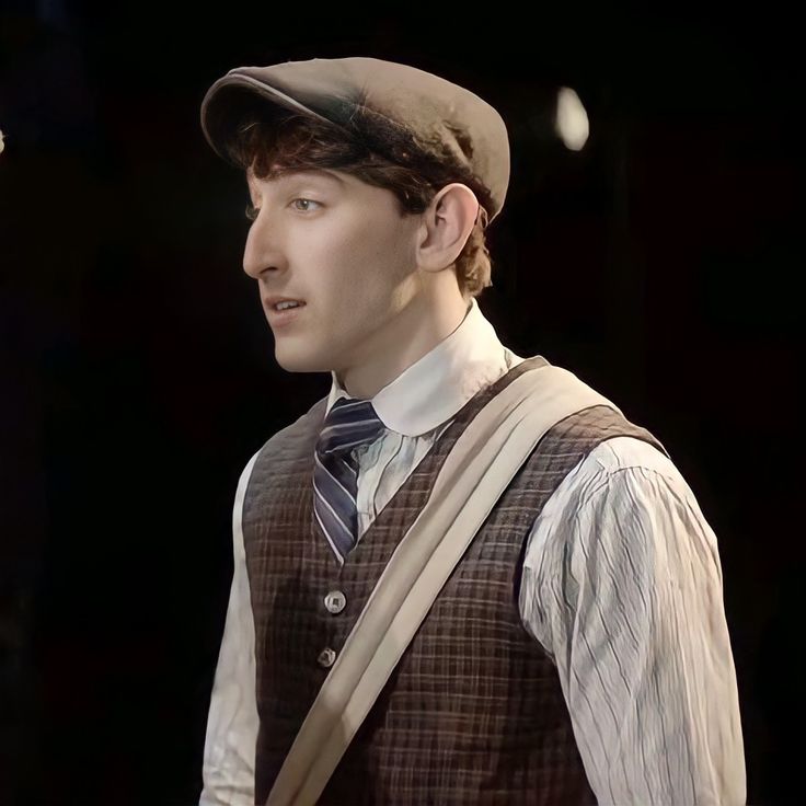 a man wearing a hat and vest with suspenders