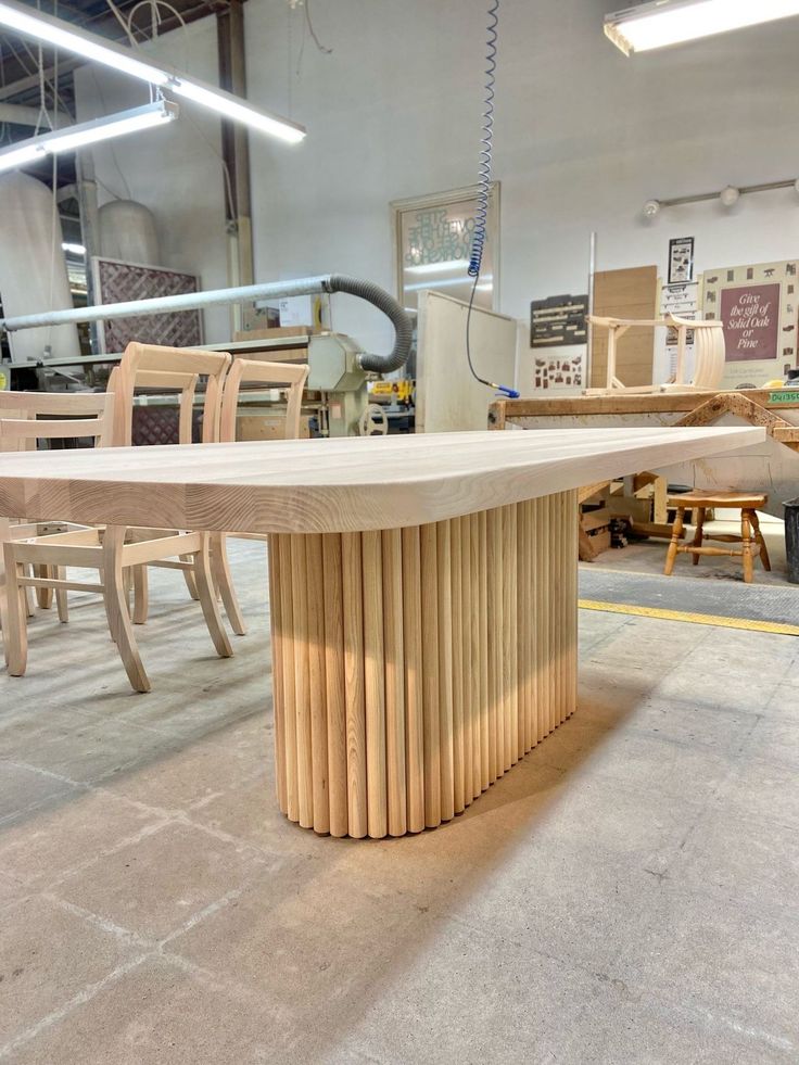 an oval table surrounded by wooden chairs in a shop