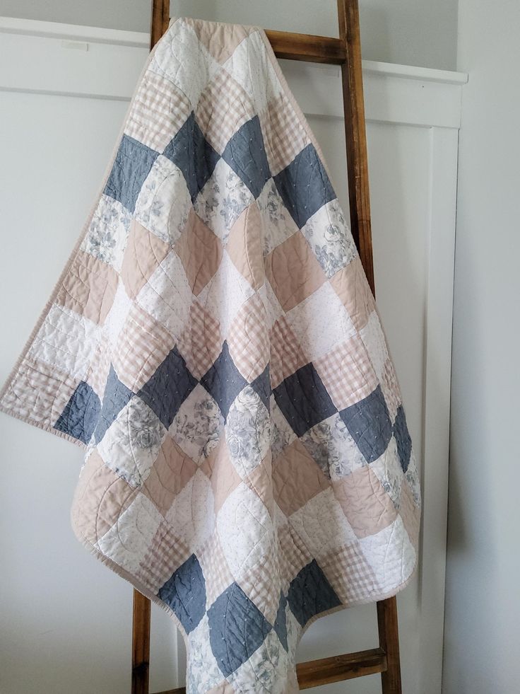 a quilt hanging on a ladder in a room