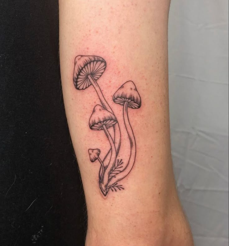 a tattoo on the leg of a woman with three mushrooms