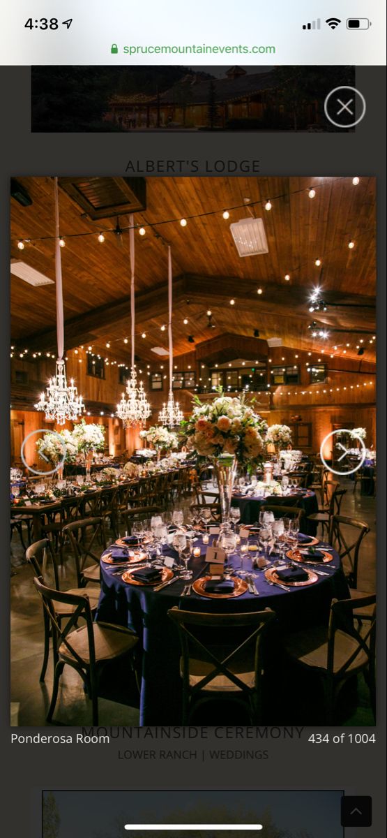 the tables are set for an event with chandeliers hanging from the ceiling