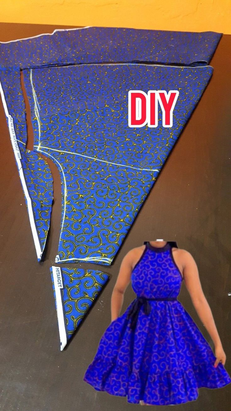 a woman in a blue dress is standing next to a kite with the word diy on it