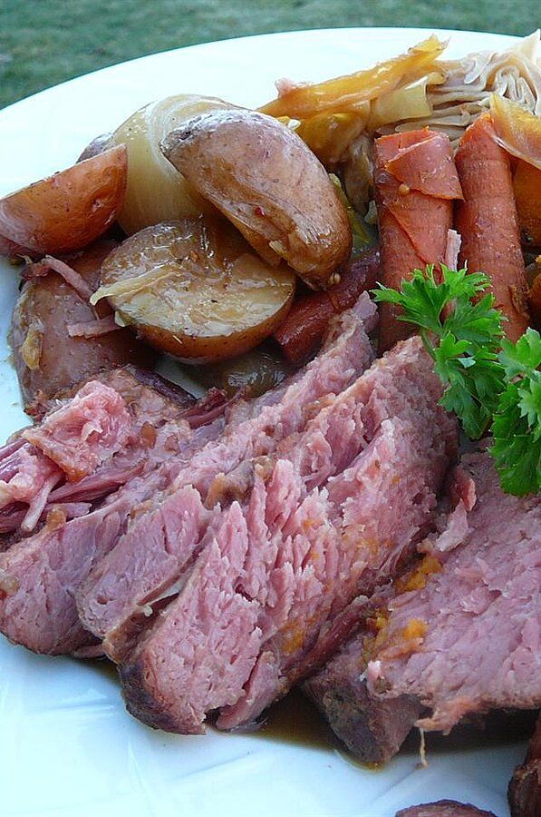 a white plate topped with meat and veggies on top of a green field