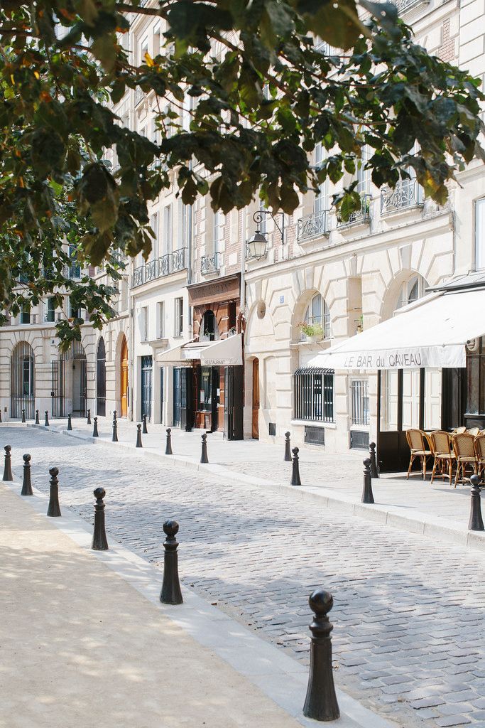 an empty street lined with tables and chairs