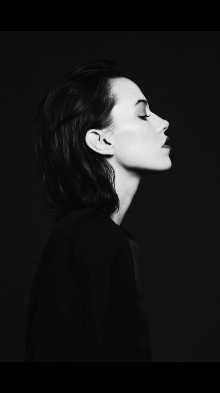 a black and white photo of a woman's face with her hair in a ponytail