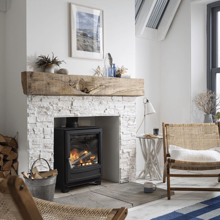 a living room with a fire place and wicker chairs next to an open fireplace