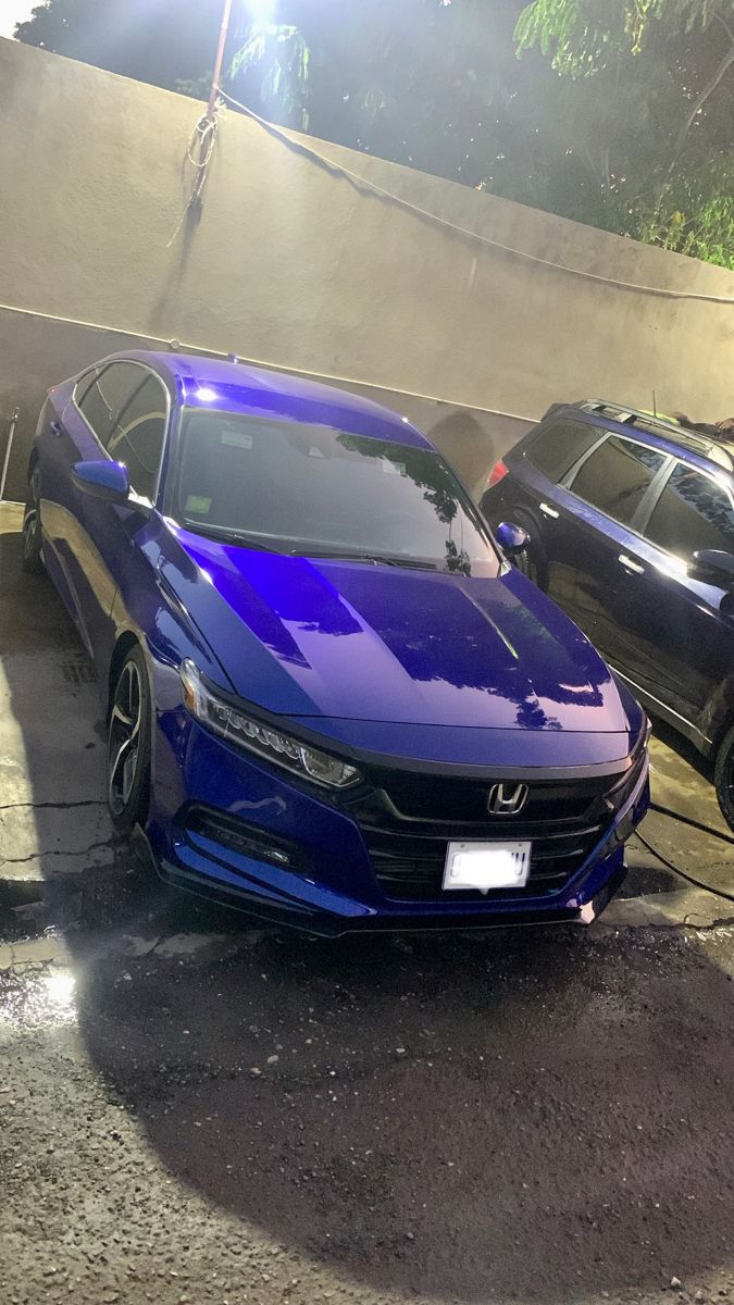 two blue cars parked next to each other in a parking lot