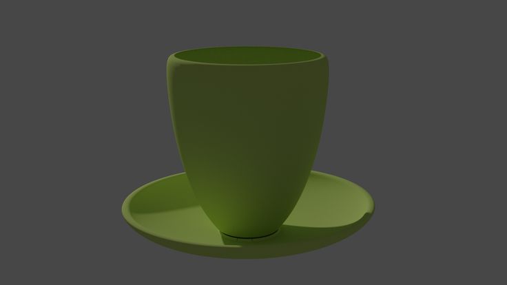 a green cup and saucer sitting on a plate in the shape of a vase