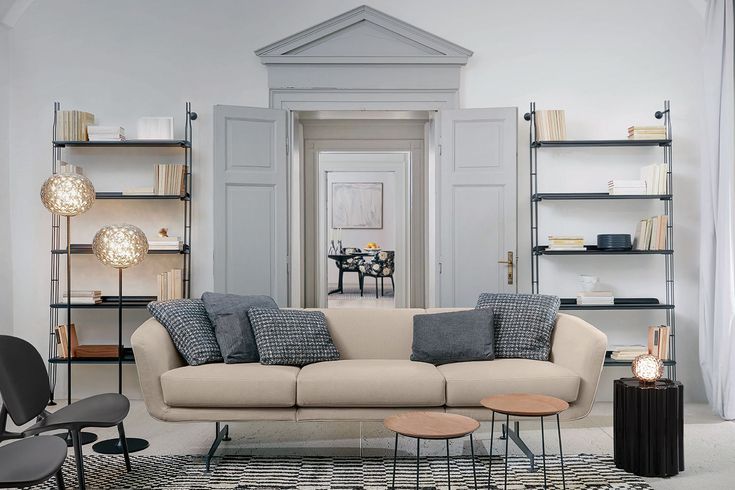 a living room filled with furniture and lots of bookshelves on the wall next to a doorway