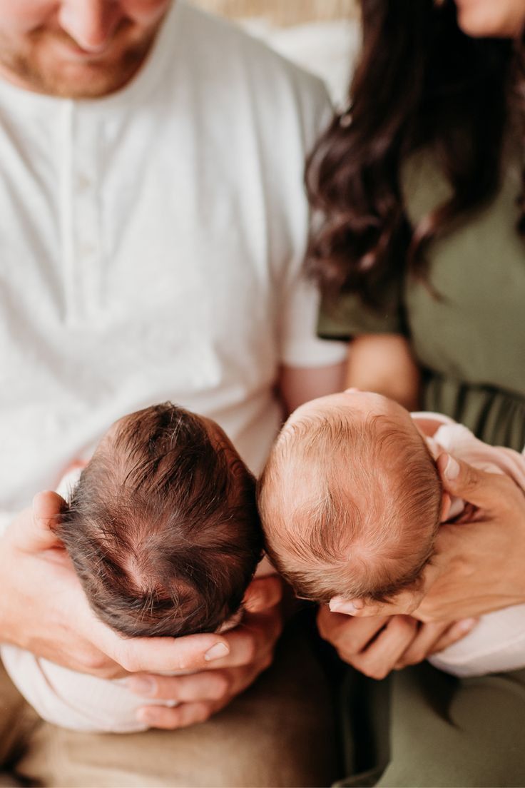 a man and woman hold their newborn baby in their arms as they look at each other