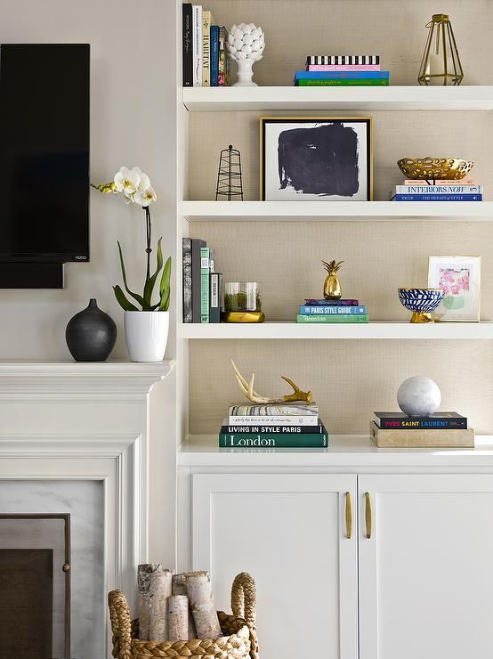 an image of a living room with bookshelves on the wall and shelves above