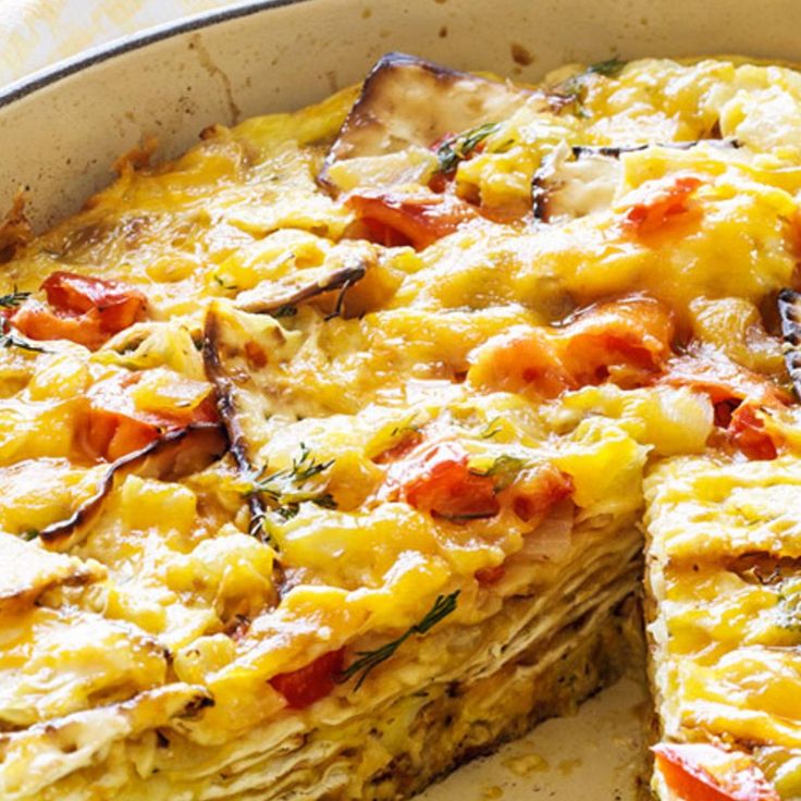 an omelet in a pan with one slice cut out and ready to be eaten